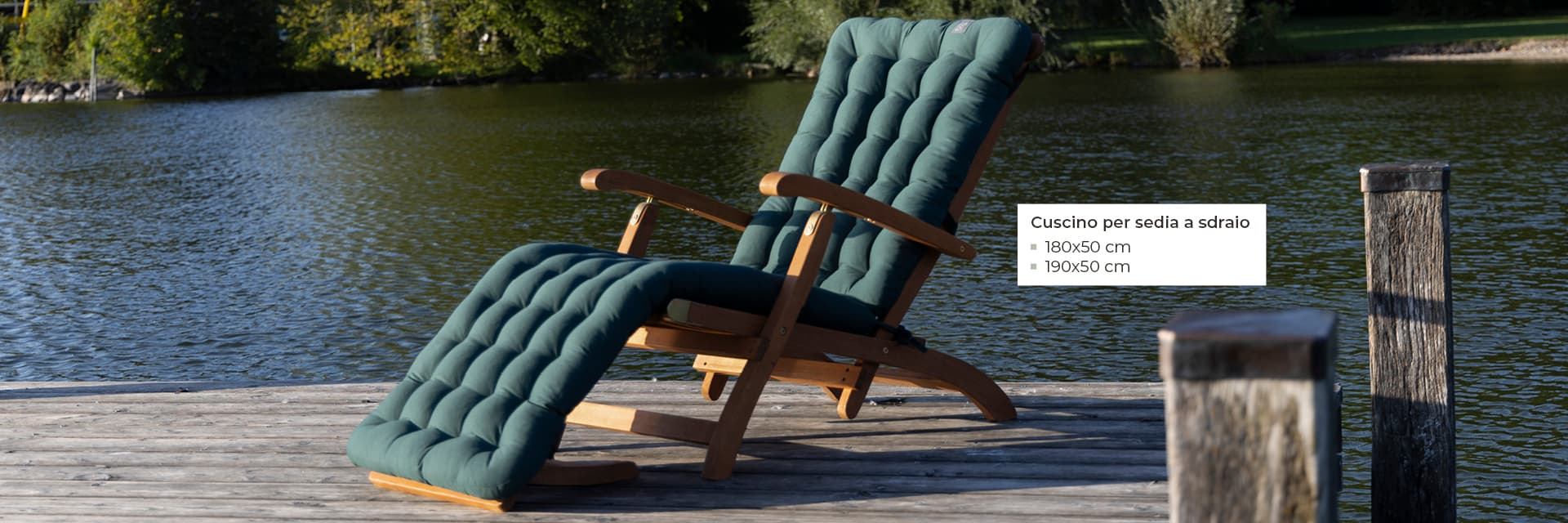 Cuscino verde per sedia a sdraio su una sedia a sdraio in legno vicino a un lago, disponibile in 180×50 cm e 190×50 cm – cuscini HAVE A SEAT per sedia a sdraio ortopedici, resistenti alle intemperie e Made in Germany.