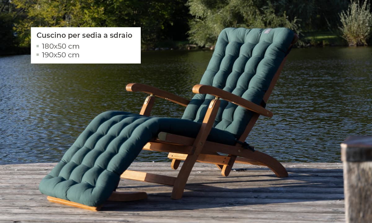 Cuscino verde per sedia a sdraio su una sedia a sdraio in legno vicino a un lago, disponibile in 180×50 cm e 190×50 cm – cuscini HAVE A SEAT per sedia a sdraio ortopedici, resistenti alle intemperie e Made in Germany.