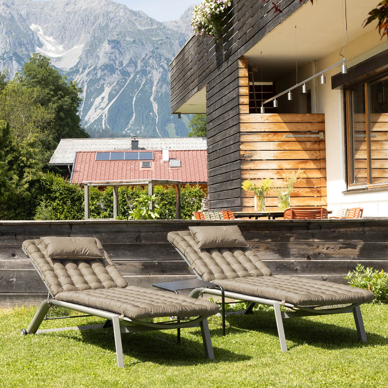 Mehrere Sonnenliegen im Garten eines Wellnesshotels mit strapazierfähigen HAVE A SEAT Living Premium-Liegenauflagen und Nackenkissen, waschbar & UV-beständig, für Hotellerie & Spa